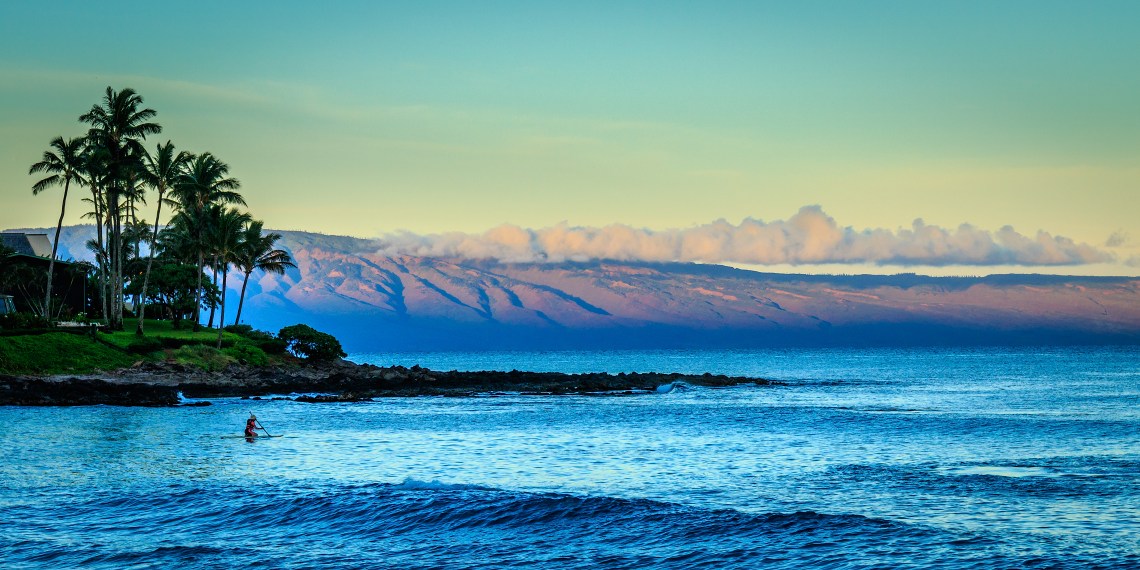 Lone paddle-boarder at sunrise