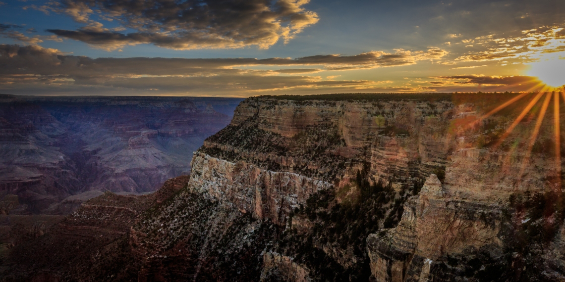 Sunrise suddenly blasts through above the clouds at Grand Canyon National Park